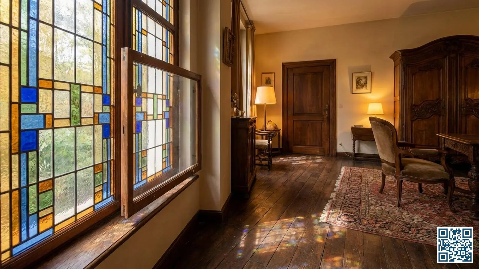 Glas-in-lood raam met voorzetbeglazing aan de binnenzijde in een traditionele Belgische woning met gekleurd licht op de houten vloer